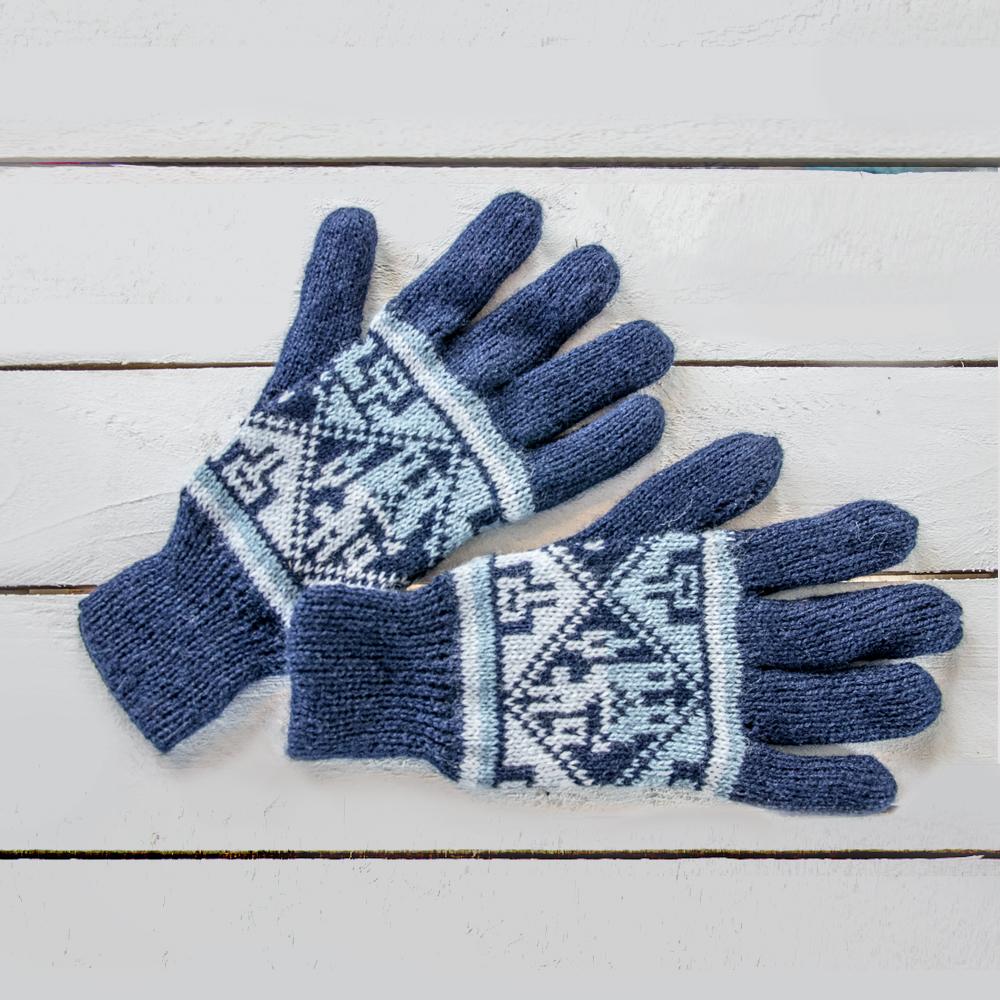 A pair of blue knitted gloves with geometric patterns on a white wooden surface.