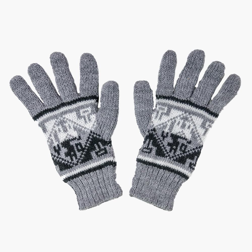 A pair of blue knitted gloves with geometric patterns on a white wooden surface.