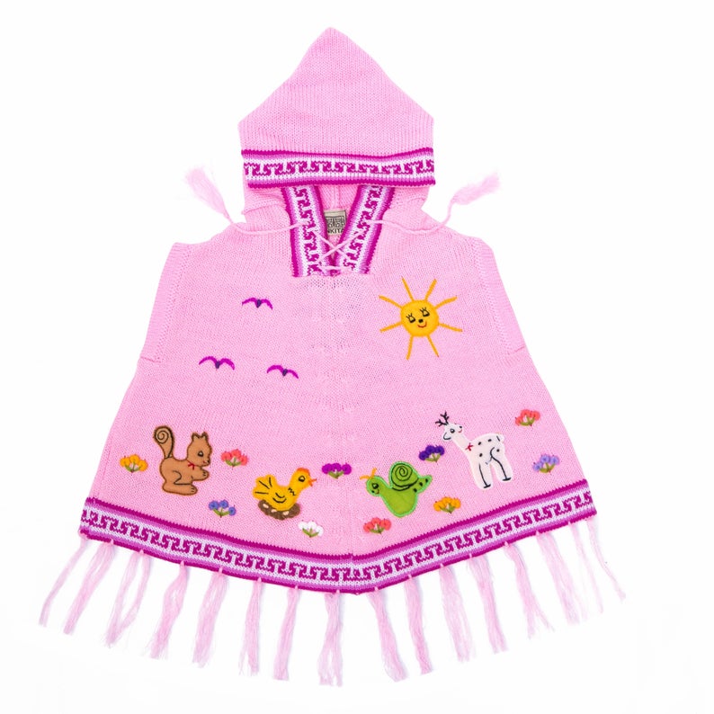 A light pink children's poncho with hood, featuring a sun and rain design with various animals and a fringed hem.
