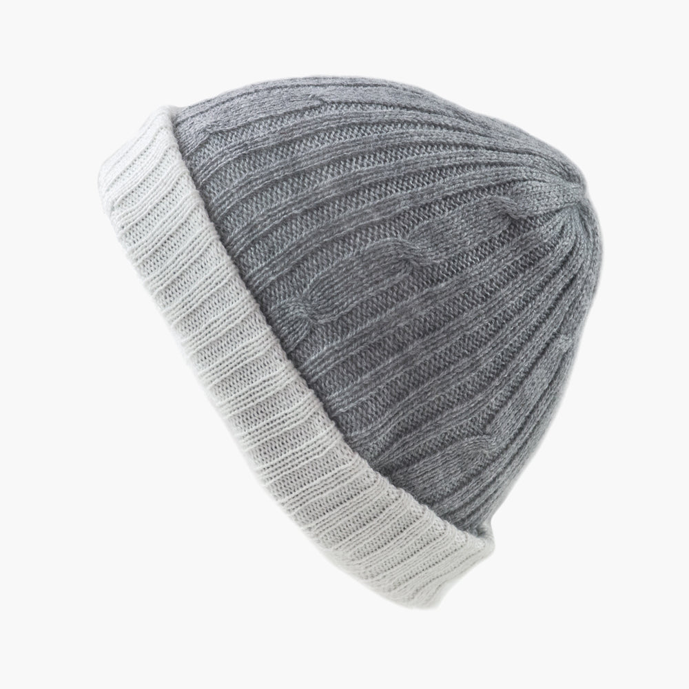 A person wearing a beige reversible hat with a red scarf.