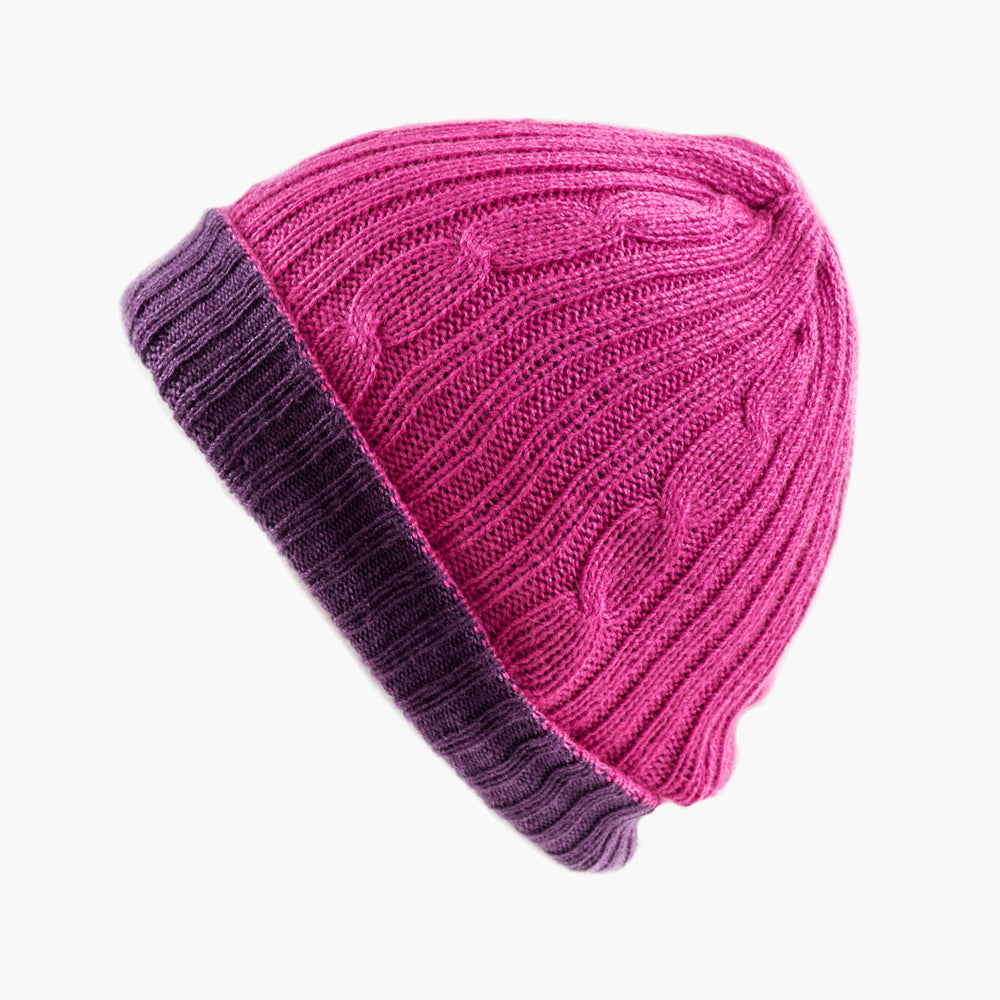 A person wearing a beige reversible hat with a red scarf.