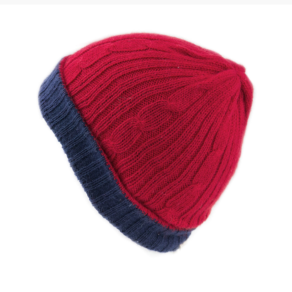 A person wearing a beige reversible hat with a red scarf.